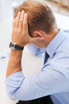 business, office, school and education concept - stressed businessman with papers at work