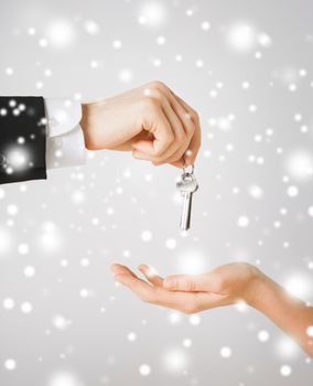 property, ownership, home, real estate concept - man hand passing house keys to woman