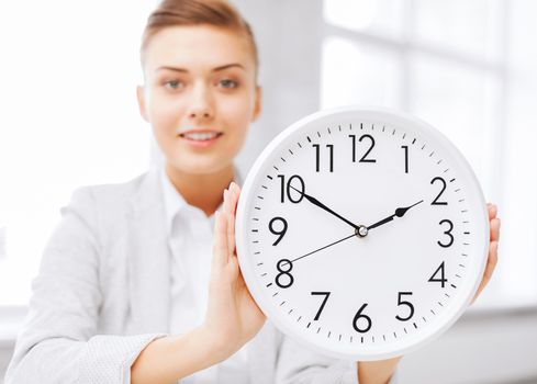 business, office, school and education concept -attractive businesswoman showing clock