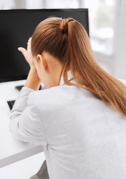 business, office, school and education concept - stressed businesswoman with computer at work