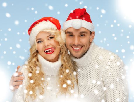 christmas, x-mas, winter, happiness concept - family couple in sweaters and santa's hats