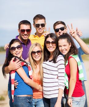 summer, holidays, vacation, happy people concept - group of friends having fun on the beach