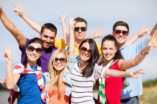 summer, holidays, vacation, happy people concept - group of friends having fun on the beach