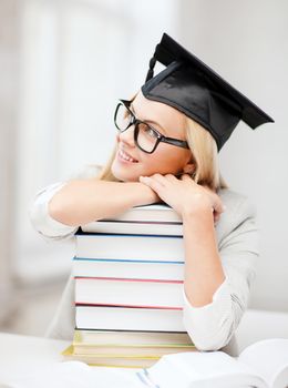business and education concept - happy student in graduation cap with stack of books