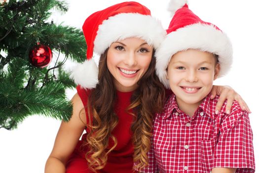 holidays, presents, christmas, x-mas concept - happy mother and child boy in santa helper hats