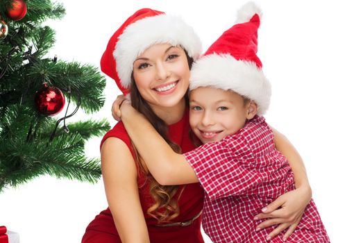 holidays, presents, christmas, x-mas concept - happy mother and child boy in santa helper hats