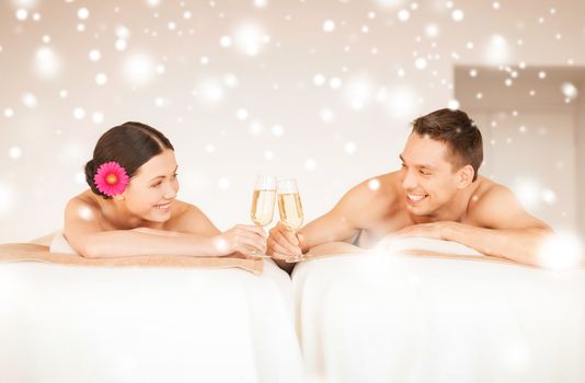 health and beauty, love, romance concept - couple in spa salon drinking champagne