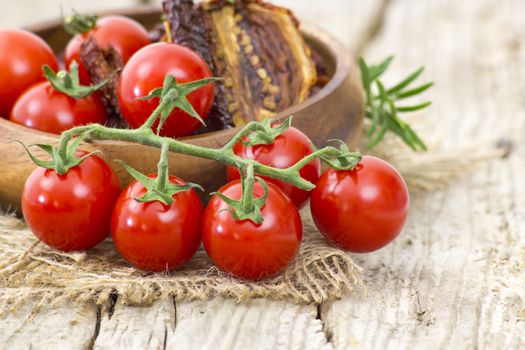 fresh and dried tomatoes on wooden background