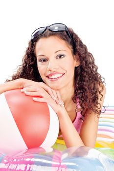 Pretty curl girl with sun glasses in hair, laying air mattress and holding the ball, isolated on white