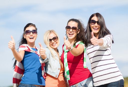 summer, holidays, vacation, happy people concept - beautiful teenage girls or young women showing thumbs up