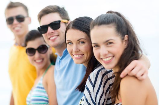 summer, holidays, vacation, happy people concept - group of friends having fun on the beach