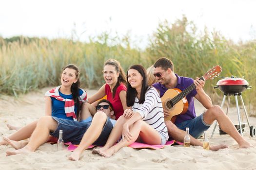 summer, holidays, vacation, music, happy people concept - group of friends with guitar having fun on the beach