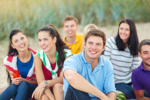 summer, holidays, vacation, happy people concept - group of friends looking up on the beach