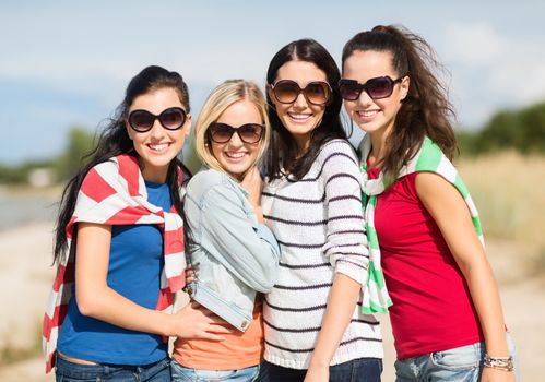 summer, holidays, vacation, happy people concept - beautiful teenage girls or young women having fun on the beach