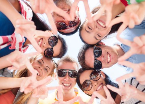 summer, holidays, vacation, happy people concept - group of teenagers looking down and showing finger five gesture