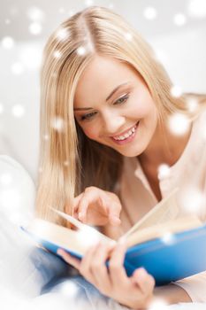 leisure and education concept - smiling woman lying on the sofa and reading book
