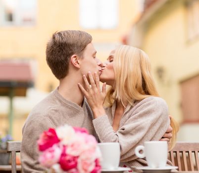 summer holidays, love, travel, tourism, relationship and dating concept - romantic happy couple kissing in the cafe