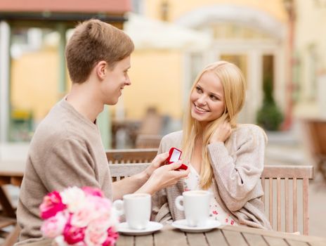 summer holidays, love, travel, tourism, relationship and dating concept - romantic man proposing to beautiful woman