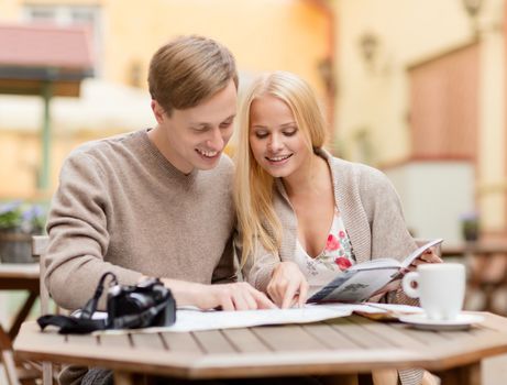 summer holidays, dating, city break and tourism concept - couple with map, camera and travellers guide