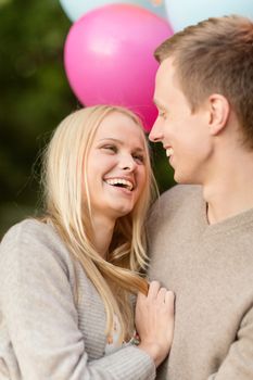 summer holidays, celebration and dating concept - couple with colorful balloons in the park