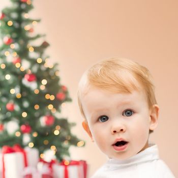 winter, people, x-mas, happiness concept - happy little boy with christmas tree and gifts