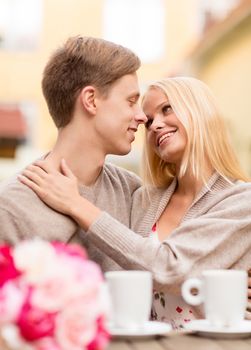 summer holidays, love, travel, tourism, relationship and dating concept - romantic happy couple kissing in the cafe