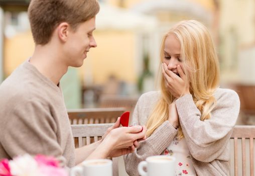 summer holidays, love, travel, tourism, relationship and dating concept - romantic man proposing to beautiful woman