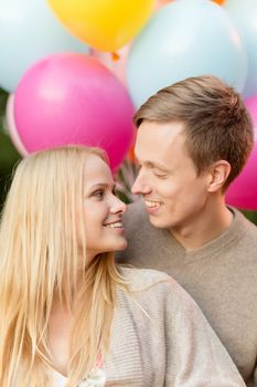 summer holidays, celebration and dating concept - couple with colorful balloons in the park