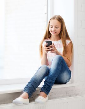 education, school, technology and internet concept - little student girl with smartphone at school