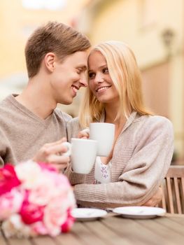 summer holidays, love, travel, tourism, relationship and dating concept - romantic happy couple kissing in the cafe