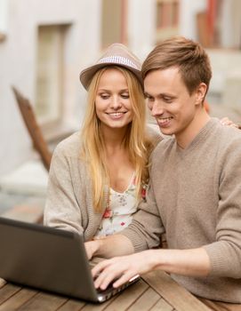 summer holidays, city, dating and technology concept - couple with laptop in cafe