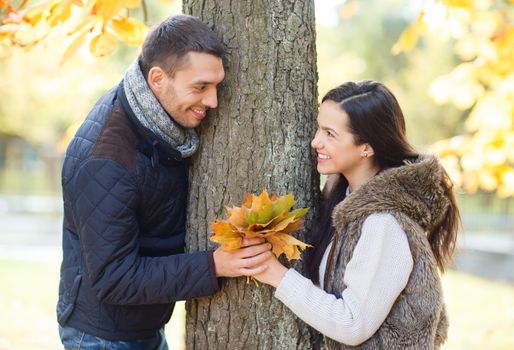 holidays, love, travel, tourism, relationship and dating concept - romantic couple playing in the autumn park