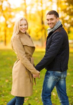 holidays, love, travel, tourism, relationship and dating concept - romantic couple in the autumn park