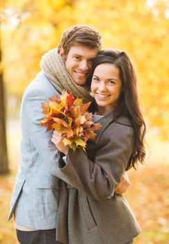 holidays, love, travel, tourism, relationship and dating concept - romantic couple in the autumn park