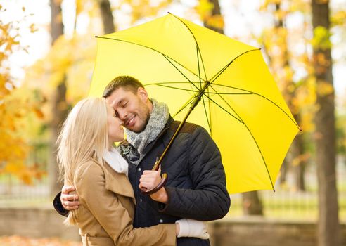 holidays, love, travel, tourism, relationship and dating concept - romantic couple kissing in the autumn park