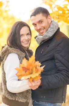 holidays, love, travel, tourism, relationship and dating concept - romantic couple in the autumn park