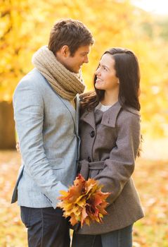 holidays, love, travel, tourism, relationship and dating concept - romantic couple kissing in the autumn park