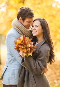 holidays, love, travel, tourism, relationship and dating concept - romantic couple kissing in the autumn park