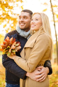 holidays, love, travel, tourism, relationship and dating concept - romantic couple in the autumn park