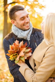 holidays, love, travel, tourism, relationship and dating concept - romantic couple in the autumn park