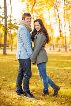 holidays, love, travel, tourism, relationship and dating concept - romantic couple in the autumn park