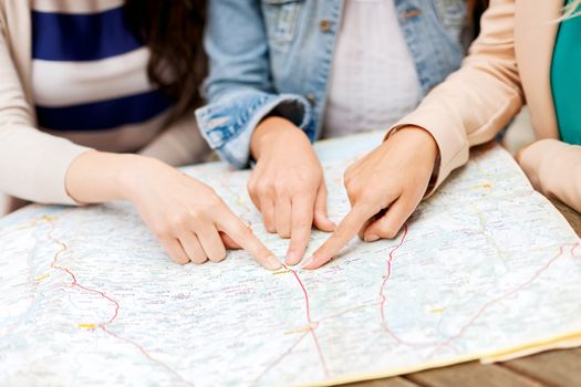 holidays and tourism concept - women with tourist map in the city