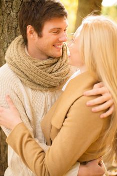 holidays, love, travel, tourism, relationship and dating concept - romantic couple kissing in the autumn park