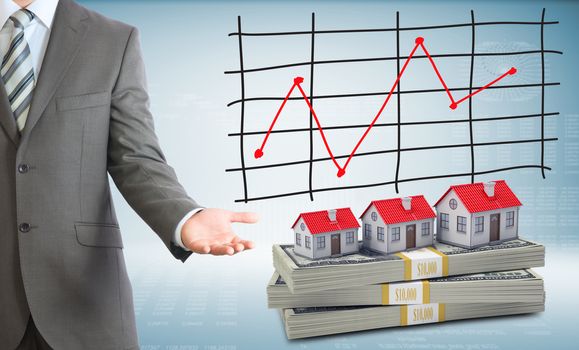 Businessman points hand on houses and packs dollars. Schedule of price increases in background