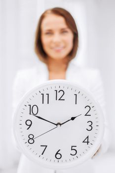 business, office, school and education concept - attractive businesswoman showing clock