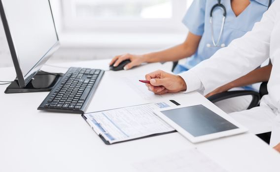 healthcare, medical and technology concept - group of doctors looking at tablet pc