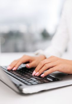 office, business, technology and internet concept - businesswoman using her laptop computer