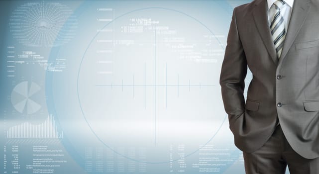 Businessman standing with hands in pockets. High-tech graphs at backdrop