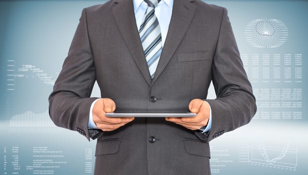 Businessman holding tablet pc. On background of the high-tech graphs