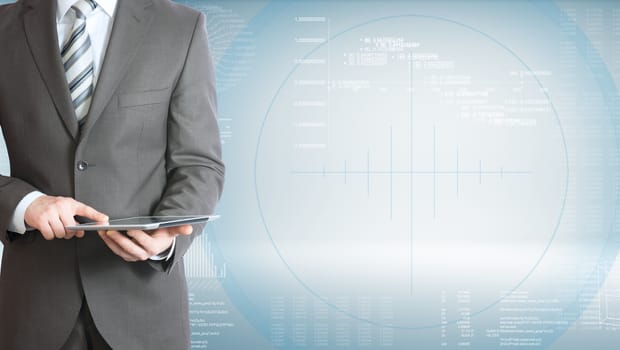 Businessman holding tablet pc. On background of the high-tech graphs